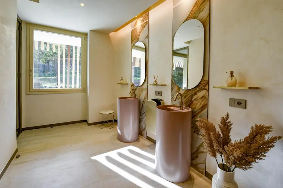 Bagno moderno con finiture in resina e lavabi rosa