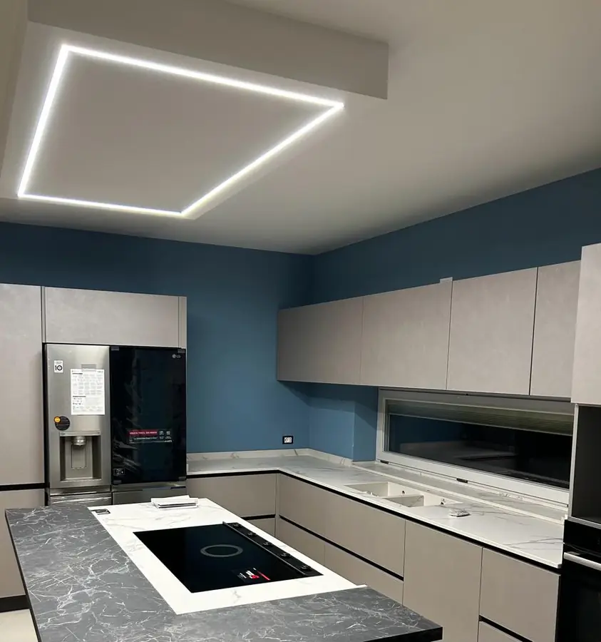 Cucina moderna con pareti blu e illuminazione a led