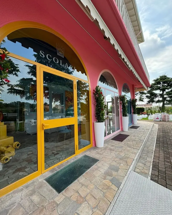 Entrata cantina Scolari con facciata rosa e serramenti gialli