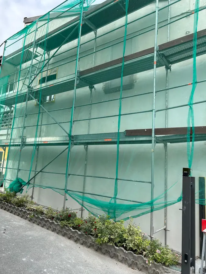 Edificio con ponteggi per isolamento termico esterno